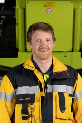 Sandro Egloff in Einsatzkleidung vor einem Feuerwehrfahrzeug